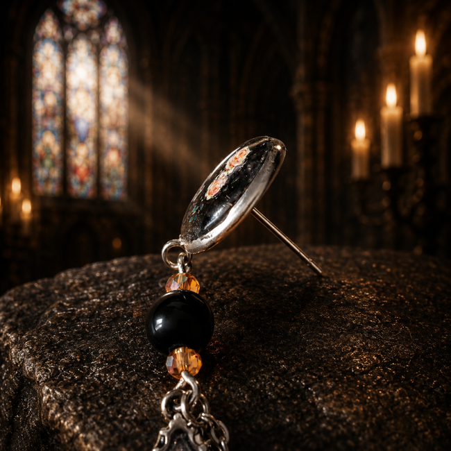 Zoom sur la fermeture et les perles noires des boucles d’oreilles Lucerna Mortis dans une ambiance de cathédrale gothique éclairée à la bougie.