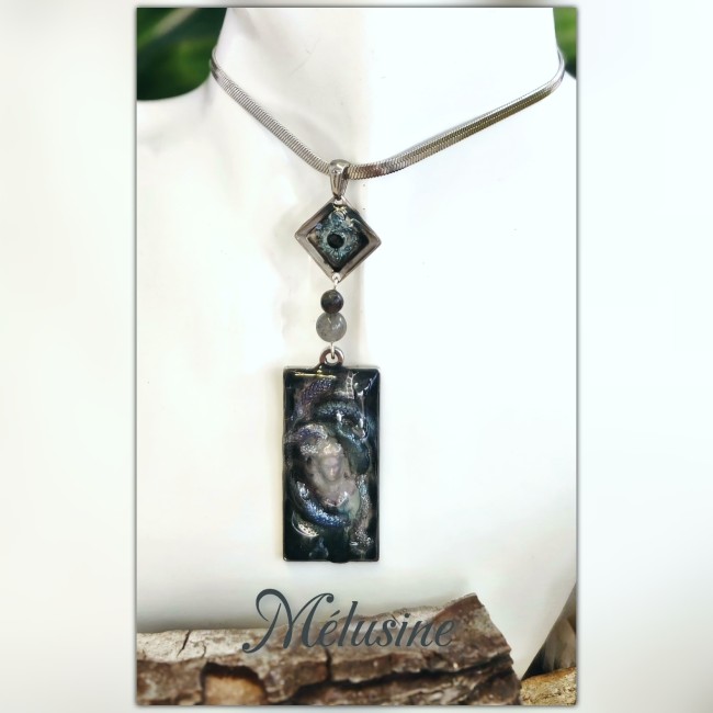 Collier artisanal Mélusine – Fantaisies d’A. Collier Mélusine issu de la collection Les Gardiens des Profondeurs : pendentif 3D en résine UV, gemmes véritables et émail transparent. Création artisanale en acier inoxydable argenté, inspirée des légendes des eaux sacrées.