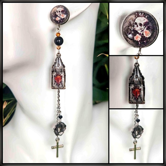 Lucerna Mortis – Argenté, bistre et une lueur d’orange, elle éclaire l’ombre d’une lumière funéraire. Chaque paire est une relique gothique, façonnée en acier inoxydable et sublimée par un travail d’émail transparent appliqué à la main, couche après couch
