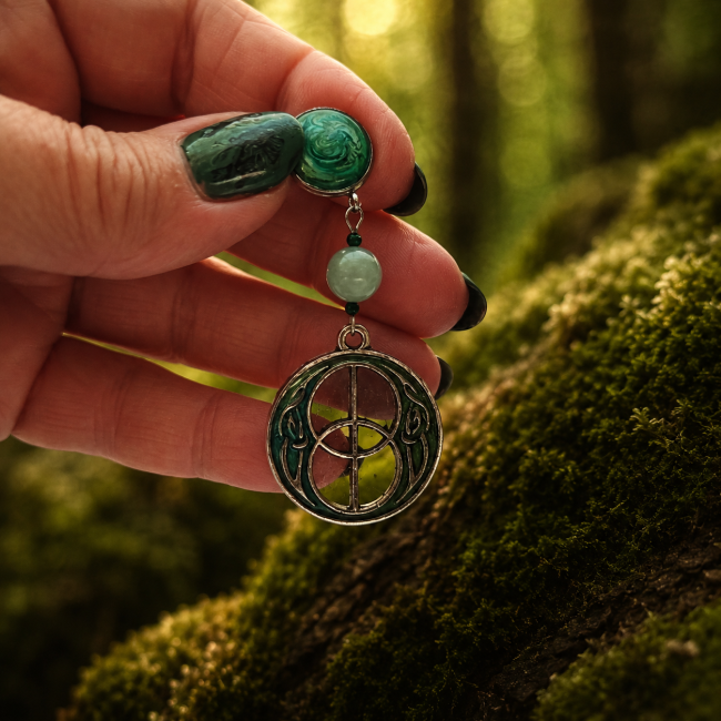 Vue rapprochée des boucles d'oreilles Nerthus mettant en valeur l'émail vert translucide, le jade naturel et les détails artisanaux. Le cœur transparent du pendentif laisse passer la lumière comme une fenêtre ouverte sur les forêts sacrées du Nord.