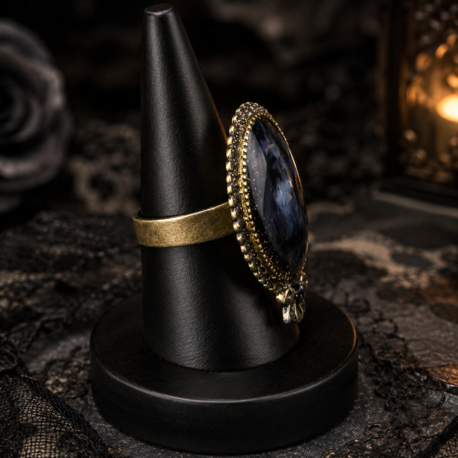 Vue de profil de la bague artisanale Celle qui demeure, mettant en évidence son médaillon ovale, son cabochon et sa monture réglable en laiton.
