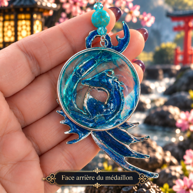 Face arrière du médaillon – La Perle de Tamatori Face arrière du médaillon du collier La Perle de Tamatori, révélant son décor émaillé bleu et turquoise et son travail artisanal.