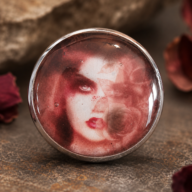 Cabochon gothique La Dame aux Roses de Cendre – Détail du bijou Gros plan sur le cabochon illustré représentant un portrait féminin mystérieux de la collection Les Portraits de Terre Noire.