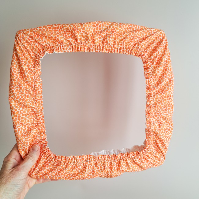 Grime guard de la collection Lumière Végétale, couleur mandarine, motif végétal orange clair – accessoire pour tambour ou Q-snap, création artisanale Angélique La fée En Fil.