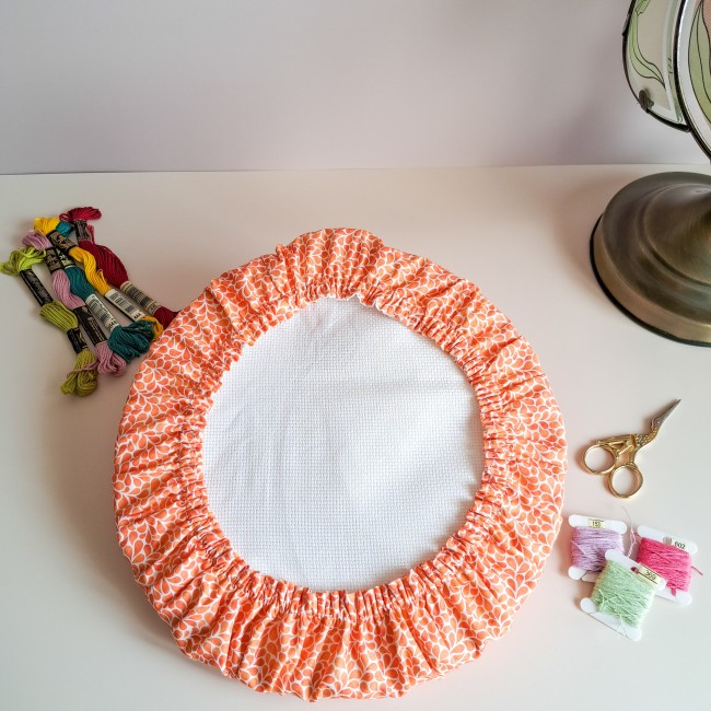 Grime Guard orange Mandarine de la boutique Angélique la Fée En Fil, adapté sur un tambour de broderie rond avec toile Aïda, fils moulinés et ciseaux de précision.