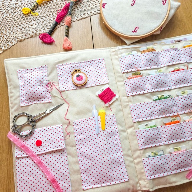 Interieur ouvert de la trousse de brodeuse Nina à pois roses, montrant les compartiments pour cartonnettes à fils, ciseaux de broderie, aimant-aiguille coccinelle et accessoires, création artisanale Angélique La Fée En Fil.