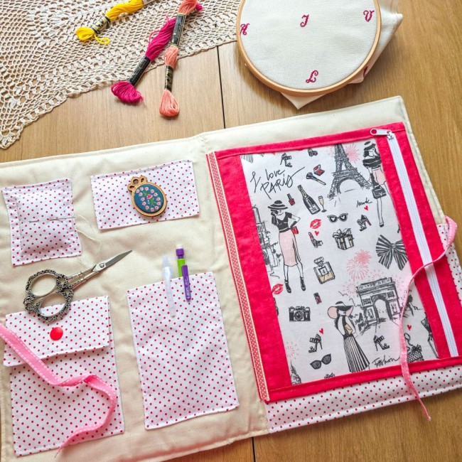 Vue intérieure de la trousse de broderie et point de croix Nina montrant la grande pochette zippée en tissu Paris, le pique-aiguille, les rangements pour ciseaux et stylos effaçables, création artisanale Angélique La Fée En Fil.