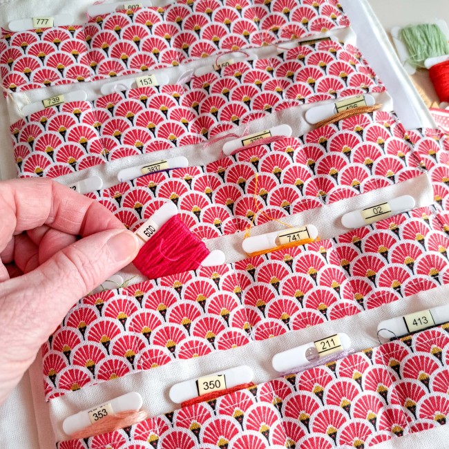 Trousse de brodeuse pour rangement de fils à broder, en tissu japonais rouge et blanc à motifs éventails, création artisanale Angélique La fée En Fil, avec échevettes et cartonnettes numérotées.