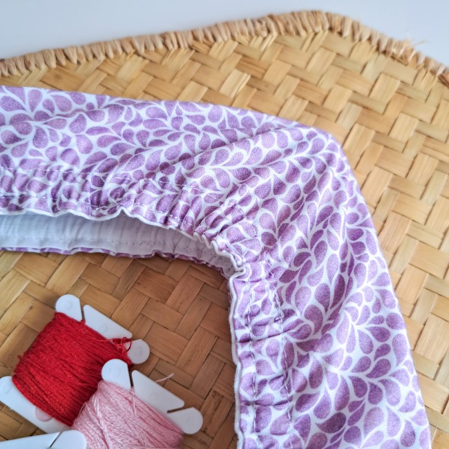 collection-lumiere-vegetale-couleur-lavande-grime-guard-brodeuse Grime guard de la collection Lumière Végétale, couleur lavande, motif végétal violet clair, présenté avec des fils à broder rouges et roses – création artisanale Angélique La fée En Fil.