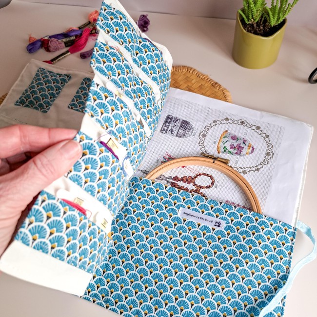 Trousse de brodeuse artisanale ouverte avec rangements pour fils à broder, tissu motif éventail bleu et poche pour tambour et grille de broderie – création Angélique La fée En Fil.