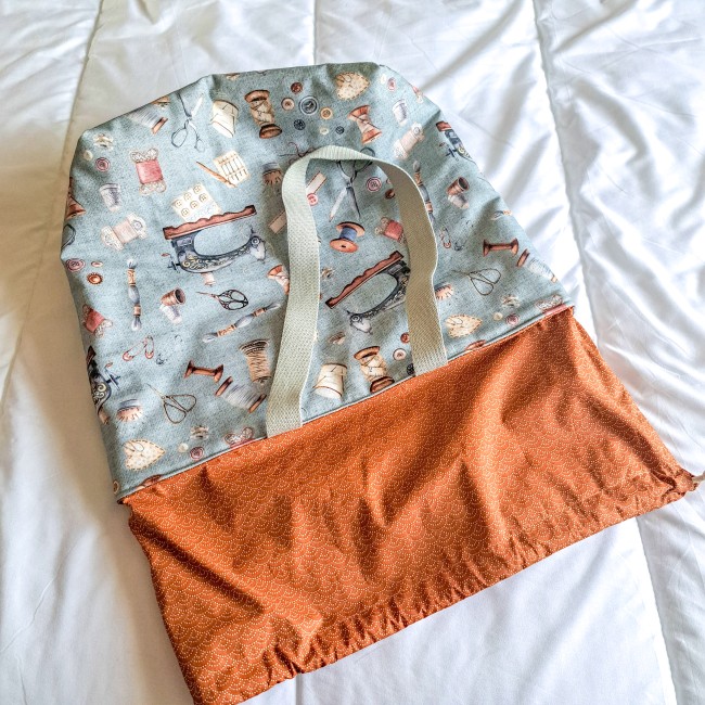 sac cabas posé sur un lit à plat pour découvrir la réhausse en tissus. sac gris imprimé accessoire couture vintage. Création Angélique La Fée En Fil. 