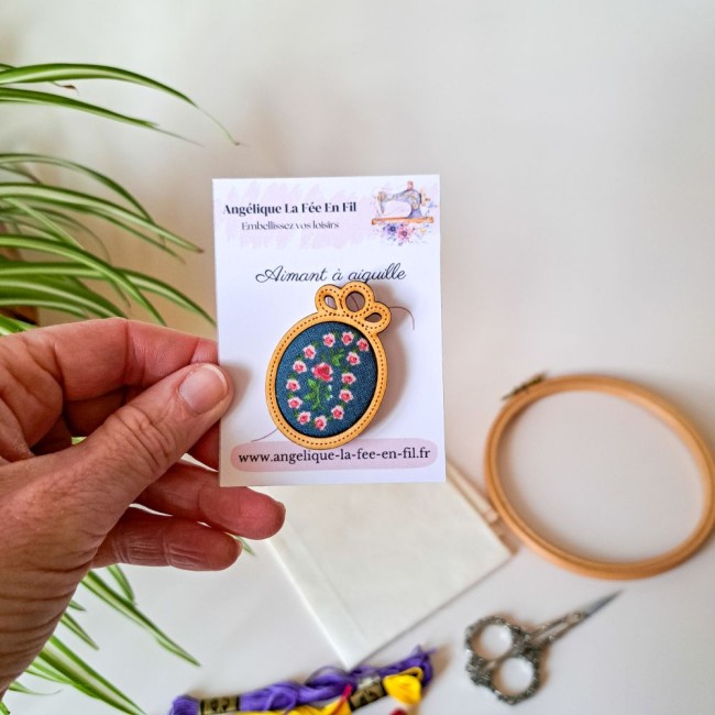 aimant-a-aiguille-fleurs-point-de-croix-bois-lucie-angelique-la-fee-en-fil needle minder tenu dans la main de la créatrice pour du point de croix