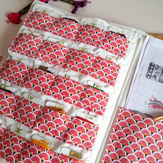 Trousse de brodeuse artisanale ouverte en tissu japonais rouge à motifs éventails, avec poches  pour fils à broder et grille de broderie insérée, création Angélique La fée En Fil.