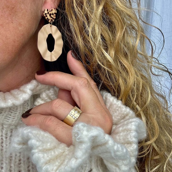 Boucles d’oreilles Alix beige avec pendentif ovale et clou cœur moucheté portées à l’oreille – DEBA CREATION