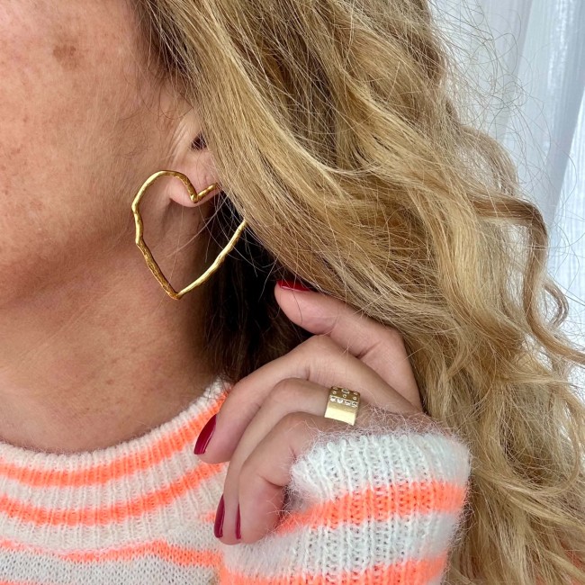 Boucle d’oreille cœur doré portée Boucle d’oreille cœur doré Nina portée avec un pull rayé rose et écru – DEBA CREATION
