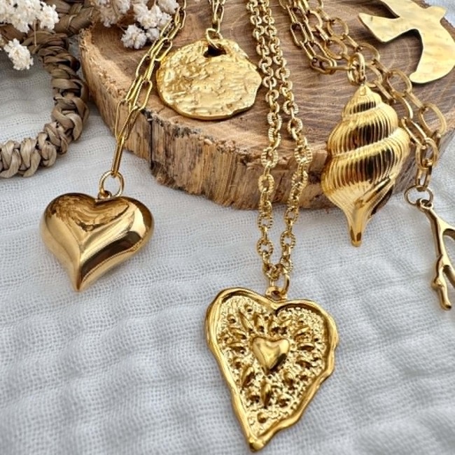Détails des pendentifs du sautoir Mélusine doré Zoom sur les pendentifs cœur coquillage corail oiseau et ovale du sautoir Mélusine