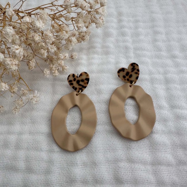 Paire de boucles d’oreilles Alix beige avec pendentifs ovales et clous cœur mouchetés sur tissu écru – DEBA CREATION
