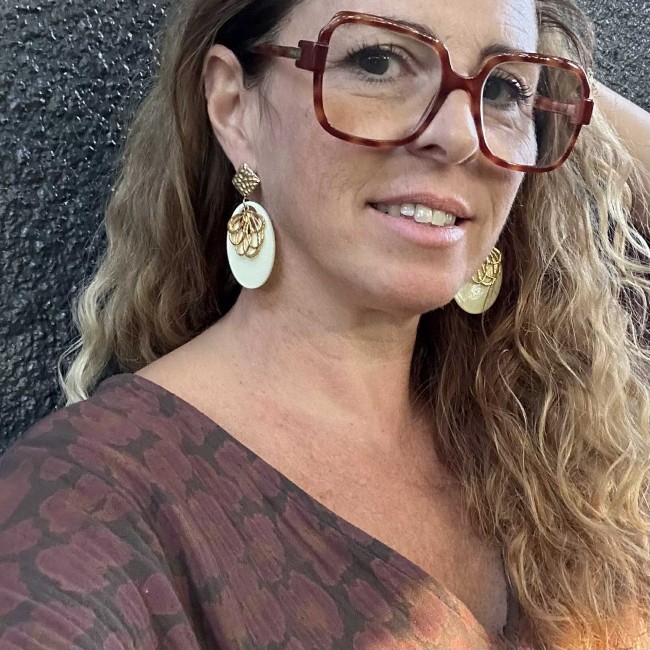 boucles d'oreilles de créateur, pendentif résine écru et fleur doré, clou oreille martelé acier inox doré, portées, atelier proche de Bordeaux
