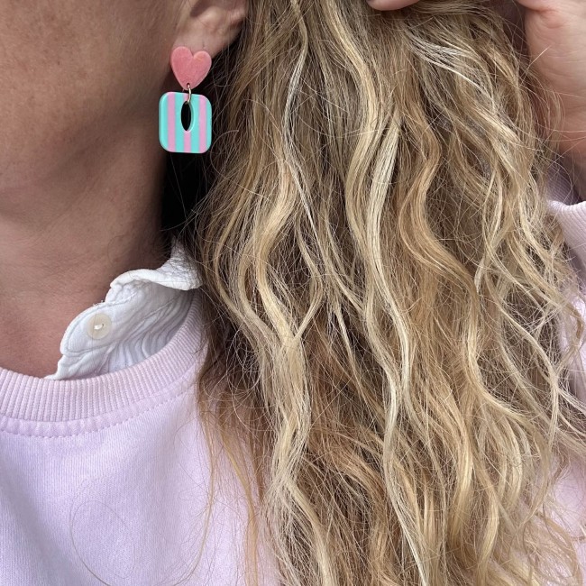 boucles d'oreilles de créateur portées, carrés colorés et rayés turquoise et rose, clou d'oreille coeur résine coloré assorti, atelier proche de Bordeaux boucles d'oreilles de créateur portées, carrés colorés et rayés turquoise et rose, clou d'oreille coeur résine coloré assorti, atelier proche de Bordeaux