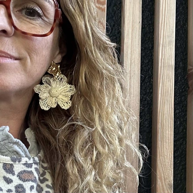 boucles d'oreilles de créateur, fleurs en raphia écru montées sur des clous d'oreilles acier inox doré étoiles martelées, portées, atelier proche de Bordeaux