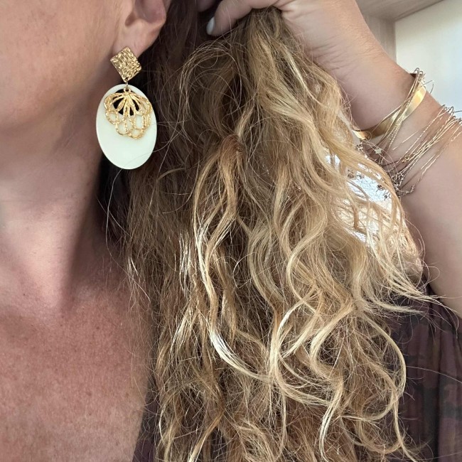 boucles d'oreilles de créateur, pendentif résine écru et fleur doré, clou oreille martelé acier inox doré, portées, atelier proche de Bordeaux