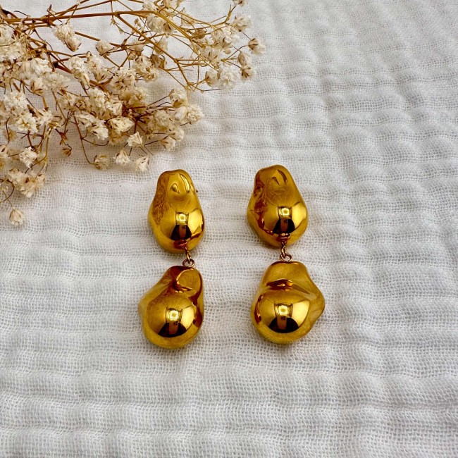 Paire de boucles d’oreilles Serena dorées Paire de boucles d’oreilles gouttes dorées Serena présentées sur tissu écru – DEBA CREATION