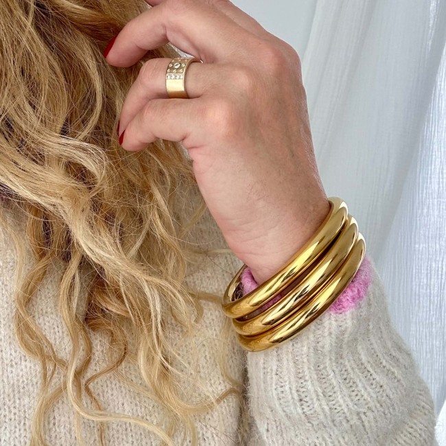 Accumulation de bracelets joncs dorés au poignet avec le bracelet Yaëlle