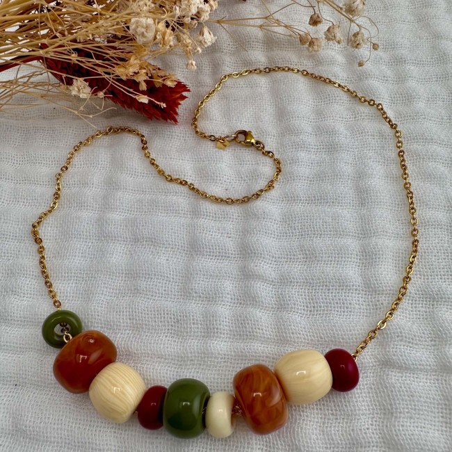 Collier Emma en perles multicolores, vue à plat Collier Emma en perles multicolores et chaîne dorée présenté seul sur tissu écru – DEBA CREATION