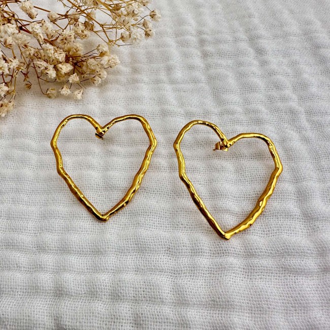 Paire de boucles d’oreilles cœur Nina Paire de boucles d’oreilles cœur dorées Nina sur tissu écru – DEBA CREATION