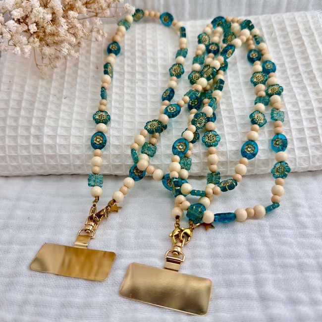 Cordon de téléphone Bouquet de Myosotis présenté avec ses perles turquoise et beige et ses plaques dorées