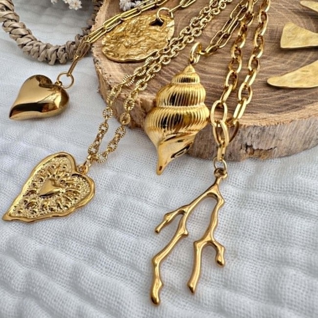 Gros plan sur les pendentifs du sautoir Mélusine Détail des pendentifs cœur corail oiseau et coquillage du sautoir Mélusine