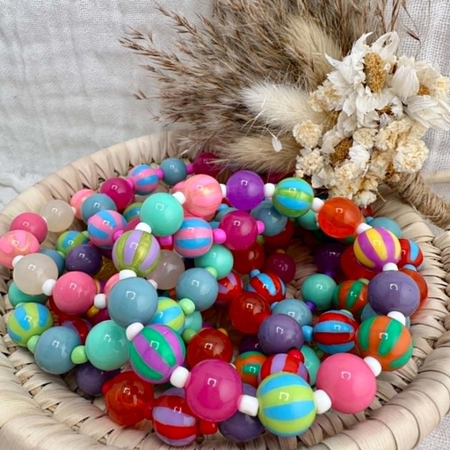 Bracelet multicolore présenté dans une coupelle décorative naturelle
