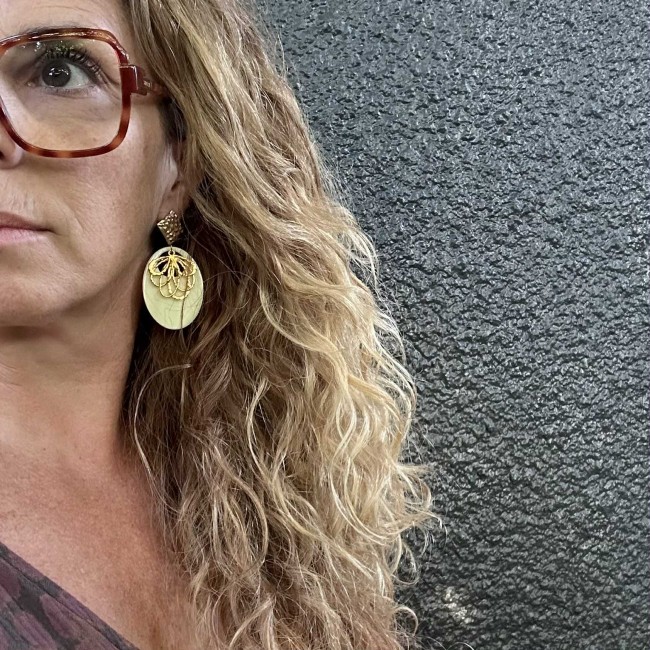 boucles d'oreilles de créateur, pendentif résine écru et fleur doré, clou oreille martelé acier inox doré, portées, atelier proche de Bordeaux