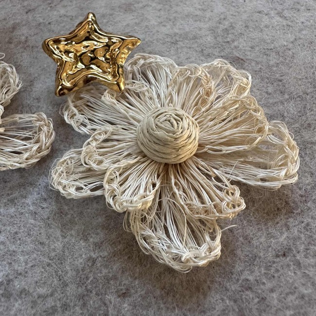 boucles d'oreilles de créateur, fleurs en raphia écru montées sur des clous d'oreilles acier inox doré étoiles martelées, atelier proche de Bordeaux