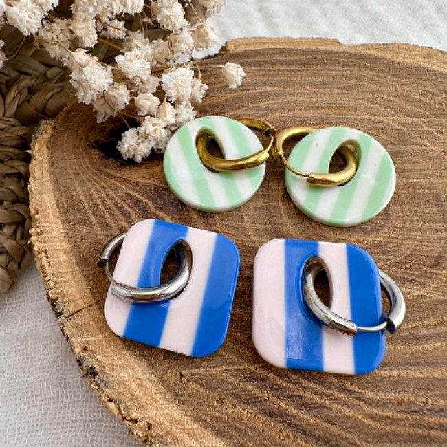 Créoles Capri rayées bleu, vert et beige présentées sur support en bois