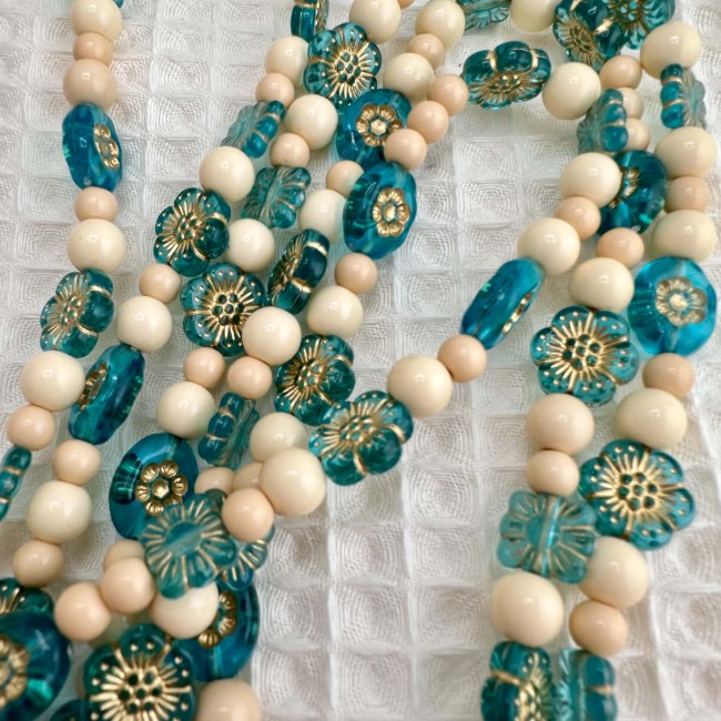 Gros plan sur les perles turquoise et beige du cordon de téléphone Bouquet de Myosotis
