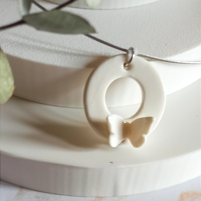 C100b - Collier court en céramique et acier inoxydable, pendentif donut papillon en porcelaine blanche - 40€ (5) Détail du pendentif donut papillon en céramique blanche émaillée