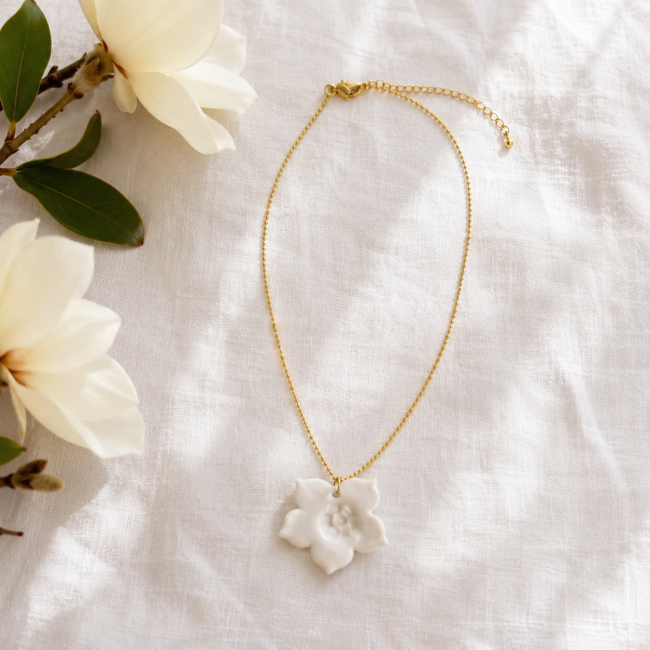 Collier fleur en porcelaine blanche sur chaîne dorée