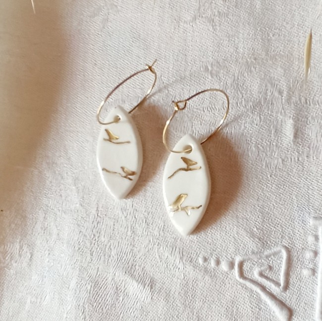 détail boucles céramique artisanale oiseau doré sur branche