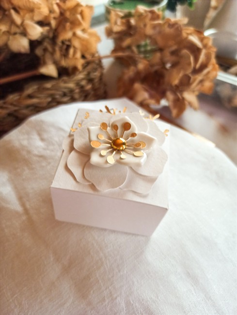 Détail d'une fleur en porcelaine blanche sur boîte à dragées