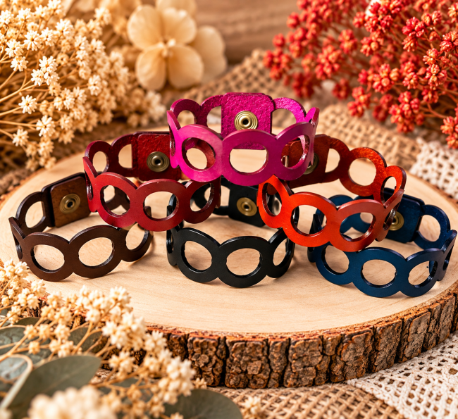 Bracelets manchettes femme en cuir découpé à anneaux ajourés, fermés par boutons-pression et superposés en plusieurs couleurs