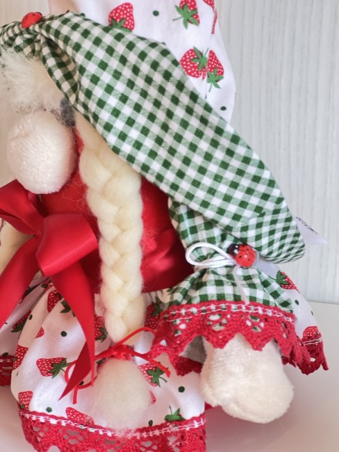 poupee-fraise-artisanale-vue-profil Zoom sur la manche vichy verte ornée d'une coccinelle décorative et de dentelle rouge de la poupée fraise artisanale.