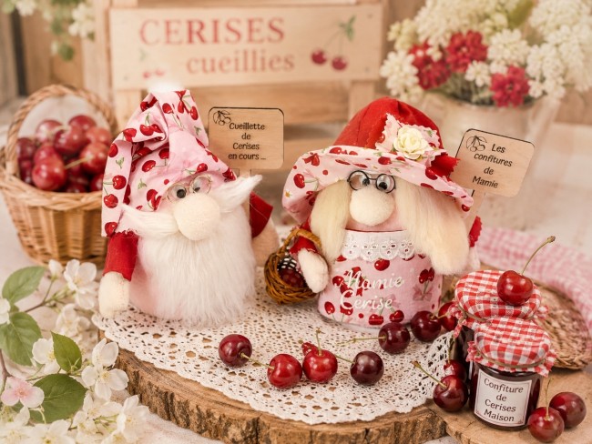 Duo de gnomes Papi et Mamie Cerise faits main sur une décoration estivale.
