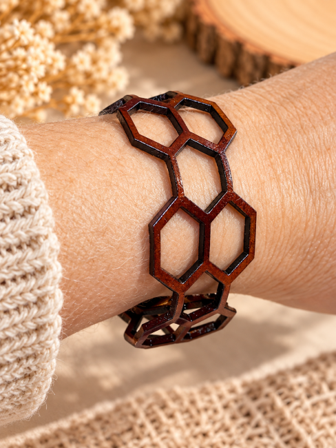 Bracelet cuir caramel mixte porté Bracelet mixte en cuir caramel porté au poignet avec motifs hexagonaux ajourés