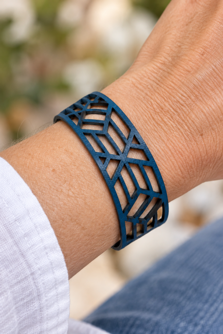 Bracelet mixte en cuir bleu ajouré – Détails de la découpe géométrique Bracelet mixte en cuir bleu porté au poignet, découpe géométrique ajourée, création artisanale française