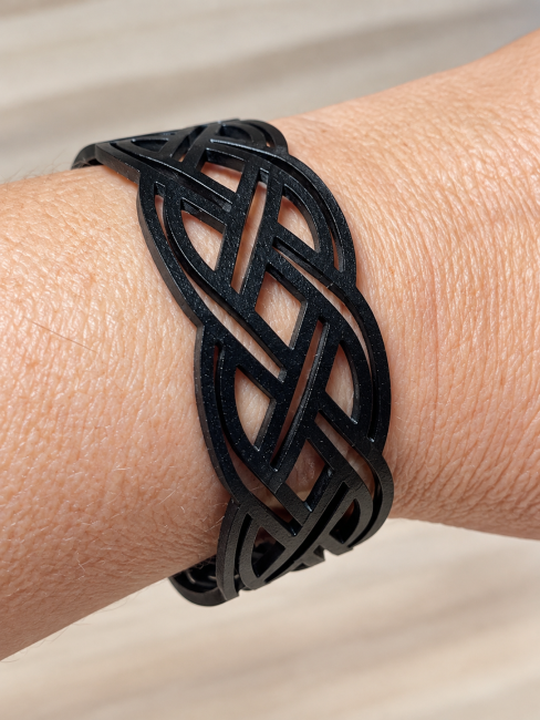 Bracelet homme en cuir noir véritable porté au poignet, découpe ajourée effet tressé