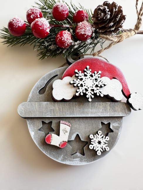 Grelot en bois découpé au laser – Détails artisanaux Vue rapprochée du grelot en bois patiné montrant la découpe laser et les détails peints