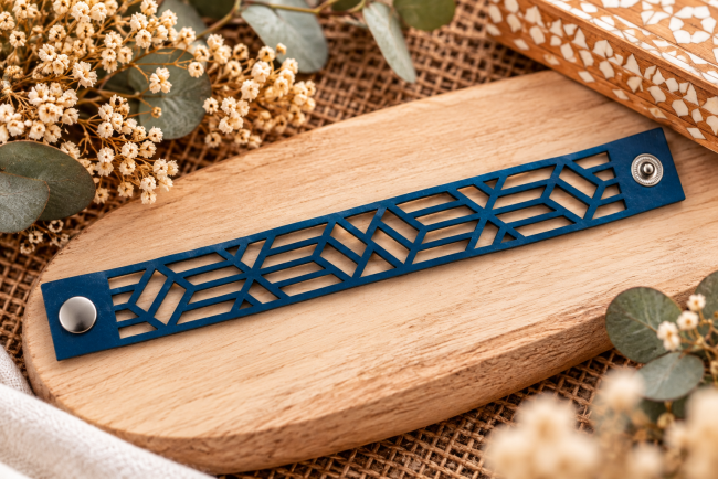 Bracelet mixte en cuir bleu ajouré – Détails de la découpe géométrique Bracelet en cuir bleu à plat avec motifs géométriques ajourés et fermeture à pression métallique, fabrication artisanale