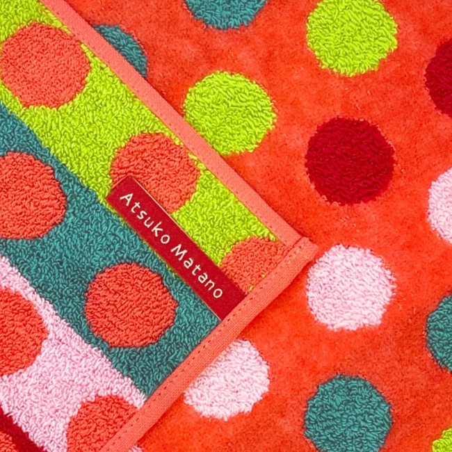 Détail de la mini serviette Drops orange Atsuko Matano Modern and Past Détail mini serviette Drops orange Atsuko Matano avec étiquette et motif pois Modern and Past