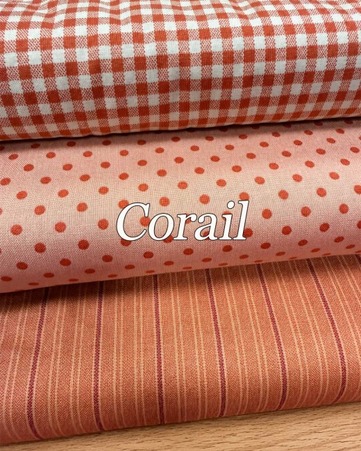 " Trois tissus coton Quiltessential Minis corail assortis : vichy, petits pois et fines rayures, présentés sur fond bois."